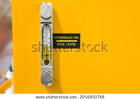 Oil sight glass level monitor for hydraulic oil and thermometer ; industrial background