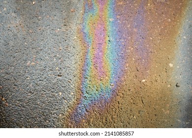 Oil Slick On The Asphalt Road Background. Rainbow Gasoline Oil Spill On The Pavement As A Texture Or Background.