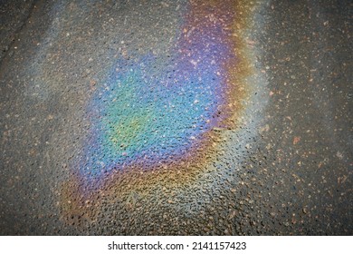 Oil Slick On The Asphalt Road Background. Rainbow Gasoline Oil Spill On The Pavement As A Texture Or Background.