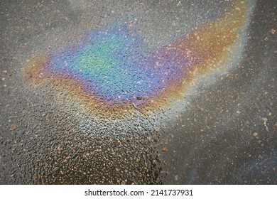 Oil Slick On The Asphalt Road Background. Rainbow Gasoline Oil Spill On The Pavement As A Texture Or Background.