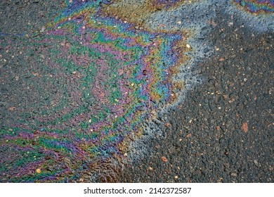 Oil Slick On The Asphalt Road Background. Rainbow Gasoline Oil Spill On The Pavement As A Texture Or Background.