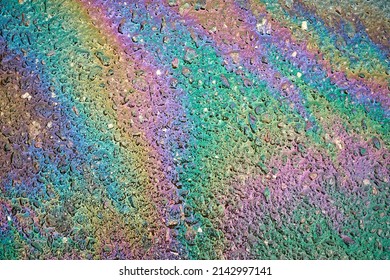 Oil Slick On The Asphalt Road Background. Rainbow Gasoline Oil Spill On The Pavement As A Texture Or Background.