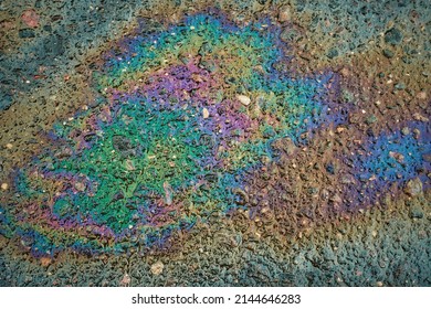 Oil Slick On The Asphalt Road Background. Rainbow Gasoline Oil Spill On The Pavement As A Texture Or Background.