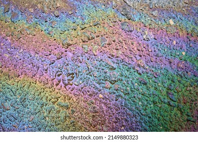 Oil Slick On The Asphalt Road Background. Rainbow Gasoline Oil Spill On The Pavement As A Texture Or Background.