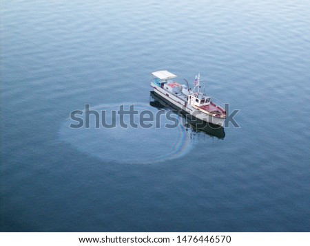 oil slick on water and water pollution and oil spill from a boat