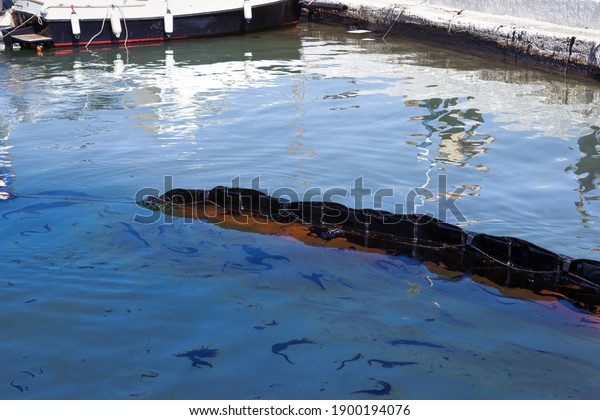 Oil spill.\
Environmental disaster. A containment boom is a temporary floating\
barrier used to contain an oil\
spill.