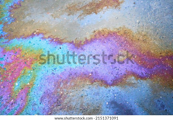 Oil stain on the\
asphalt, rainbow-shaped colored gasoline stains on an asphalt road\
as a texture or background