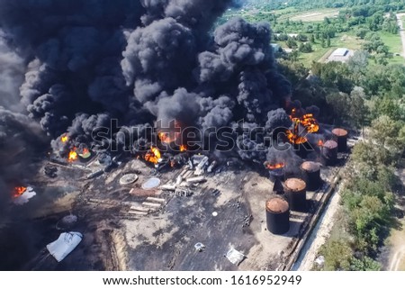 Oil storage fire. The tank farm is burning, black smoke is the combustion of hydrocarbons.