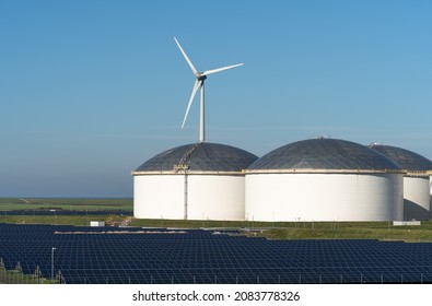 Oil Storage Tanks, Solar Panels And A Wind Turbine.