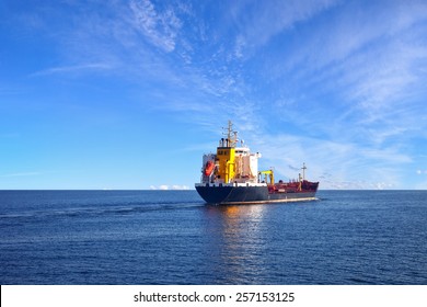 Oil Tanker Ship At Sea On A Background Of Blue Sky.