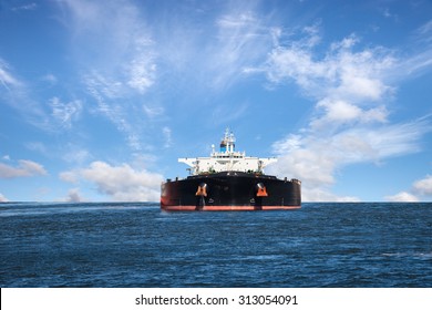 Oil Tanker Ship At Sea On A Background Of Blue Sky.