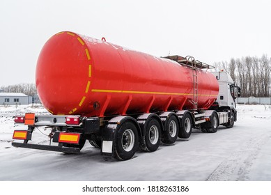 Oil tanker truck with a red tank semi-trailer. The picture was taken in Russia, in winter in snowfall - Shutterstock ID 1818263186