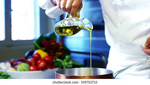 Oil That Falls From A Small Bottle. The Dietary Oil And Bio Used To Flavor Foods Falls In Slow Motion. Concept Of Dieting, Food, Tradition, Italy