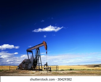 An oil well with the pump jack in action. Located in the province of Alberta, Canada.