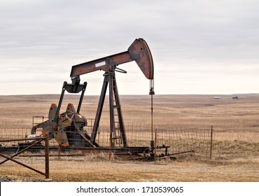 Oil Well Pump Jack Pumping Crude Oil For Fossil Fuel Energy. American Petroleum Oil And Gas Industry Equipment Extracting From A Field On A Prairie In The United States Of America.