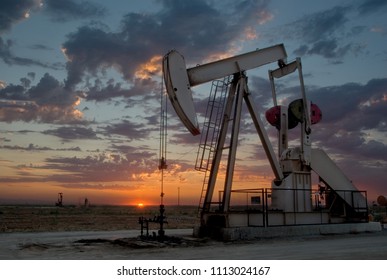 Oil Well, Pump Jack, In The San Joaquin Valley Of Central California At Sunset. Oil Industry Background. 