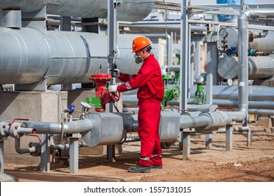 Oil Worker In Red Work Wear, Orange Helmet And Gas Mask On Oil Refinery Plant (gas  Processing  Plant) In Desert. CNPC Company