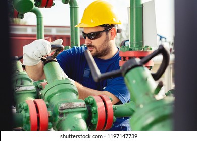 Oil Worker Turning Valve On Oil Rig