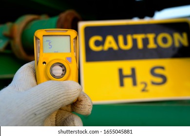 Oilfield technician checking H2S gas with his pocket type H2S Gas detector  in gas plant. 