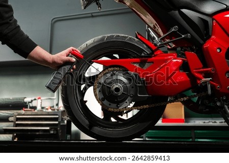Oiling motorcycle chain helps reduce wear, prevent rust, and ensure clean drivetrain for top riding performance. Motorcycle Chain Lubrication with Oil. Clean oil spray is applied to motorcycle chain