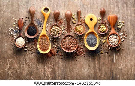 Oilseeds in wooden spoon on wooden background 