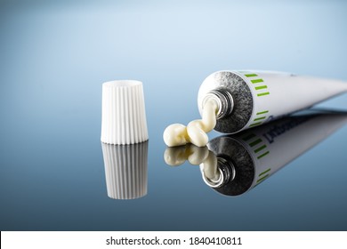 ointment or gel for external use is slightly squeezed out of the tube next to the cap on a gradient background with reflection - Shutterstock ID 1840410811