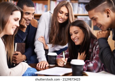 OK, enough about friday night...lets start studying. Cropped shot of a group of university students doing a group project in the campus library. - Shutterstock ID 2129873423