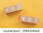 OK or NG; Wooden blocks with "OK? NG?"  text of concept.