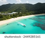 Okinawa, Japan: Aerial of a boat leaving the Aharen beach in the Tokashiki island, a popular summer destination, in Okinawa in the Pacific Ocean.