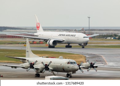 Okinawa, Japan. December 5, 2018. Japan Airlines Boeing 777-246 Reg. JA8985 Taxi To Gate Terminal After Land At Naha Airport With Aircraft Of Japn Maritime Self Defence Force  Foreground