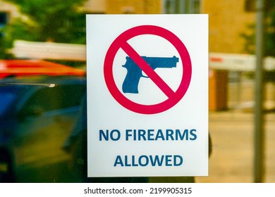 Oklahoma City Oklahoma - Circa August 2022   

Sign No Firearms Allowed Posted On Glass Door Reflecting A Police Car
