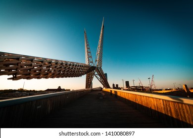 "Oklahoma City, OK / USA - 4/25/2019 : The Scissortail Bridge angles intself toward Downtown Oklahoma CIty with a unique dark teal and orange tone."