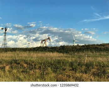 Oklahoma Landscape With Windmill, Pump Jack And Wind Turbine In The Horizon