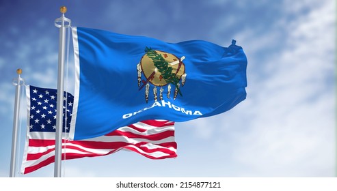 The Oklahoma State Flag Waving Along With The National Flag Of The United States Of America. Oklahoma Is A State In The South Central Region Of The United States