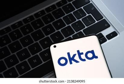 Okta security firm logo seen on smartphone and a laptop on blurred background. Concept for company hack. Stafford, United Kingdom, March 22, 2022.
