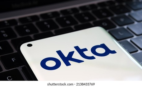 Okta security firm logo seen on smartphone and a laptop on blurred background. Concept. Selective focus. Stafford, United Kingdom, March 22, 2022.