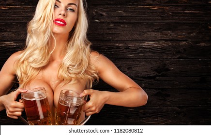 Oktoberfest Beer fest. Young sexy and naked woman, serving big mugs on wood background.