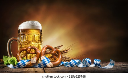 Oktoberfest beer with pretzel, wheat and hops on wooden table - Shutterstock ID 1156625968