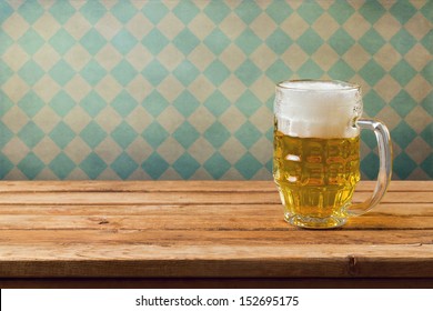 Oktoberfest Holiday. Beer On Wooden Table Over Retro Wallpaper With Bavarian Flag Pattern