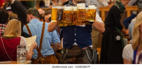 Oktoberfest, Munich, Germany. Waiter With Traditional Costume Serving Beers, Closeup View