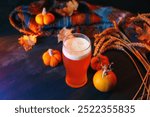 Oktoberfest or Thanksgiving beer on the table. Pumpkin ale , autumn decorations