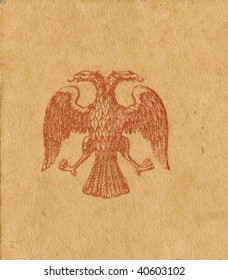 old 1900's double-headed eagle stamp on grungy postcard background. scanned object. original texture and color are preserved