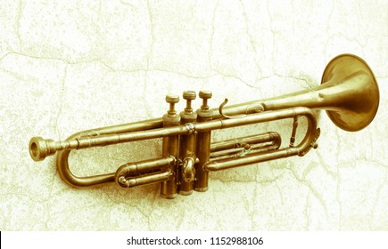 An Old 1920s Jazz Trumpet Hanging On A Wall With Cracks