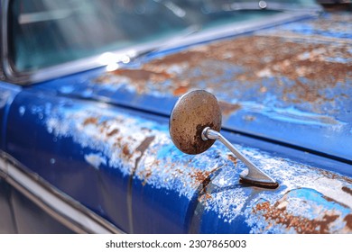 An old 1960s classic-style car that has rusted is parked and unused only used as ornament in front of the café - Powered by Shutterstock