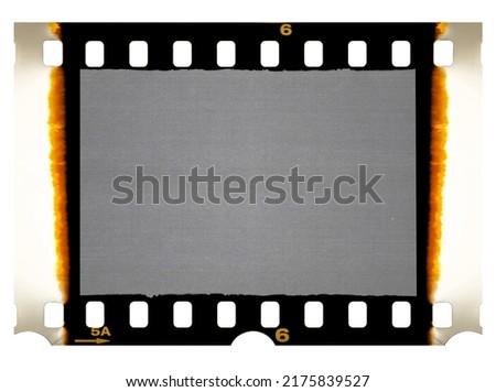 Old 35mm filmstrip or dia slide frame with burned edges isolated on white background. Real analog film scan with signs of usage.