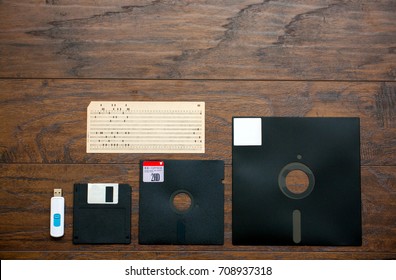 The old 8-inch, 5.25-inch, 3.5-inch floppy disk, punched card for an old ibm computer, a comparison with the USB flash drive