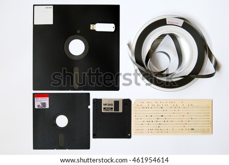 The old 8-inch floppy disk, magnetic tape for an old computer, punched card, a comparison with the flash drive