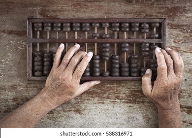 old abacus and hand on wooden background