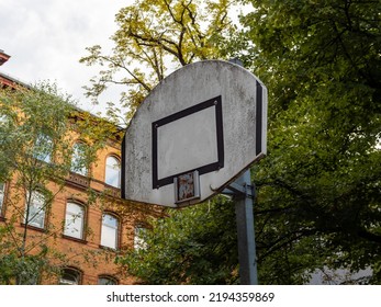 Old Abandoned Basketball Court With A Broken Basket. The Backboard Is Very Dirty And Weathered. Nobody Will Do Sport Again At This Place. There Is No Money For New Equipment.