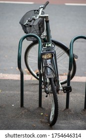 Old Abandoned Bicycle With Broken Bent Wheel Locked To A Stand.